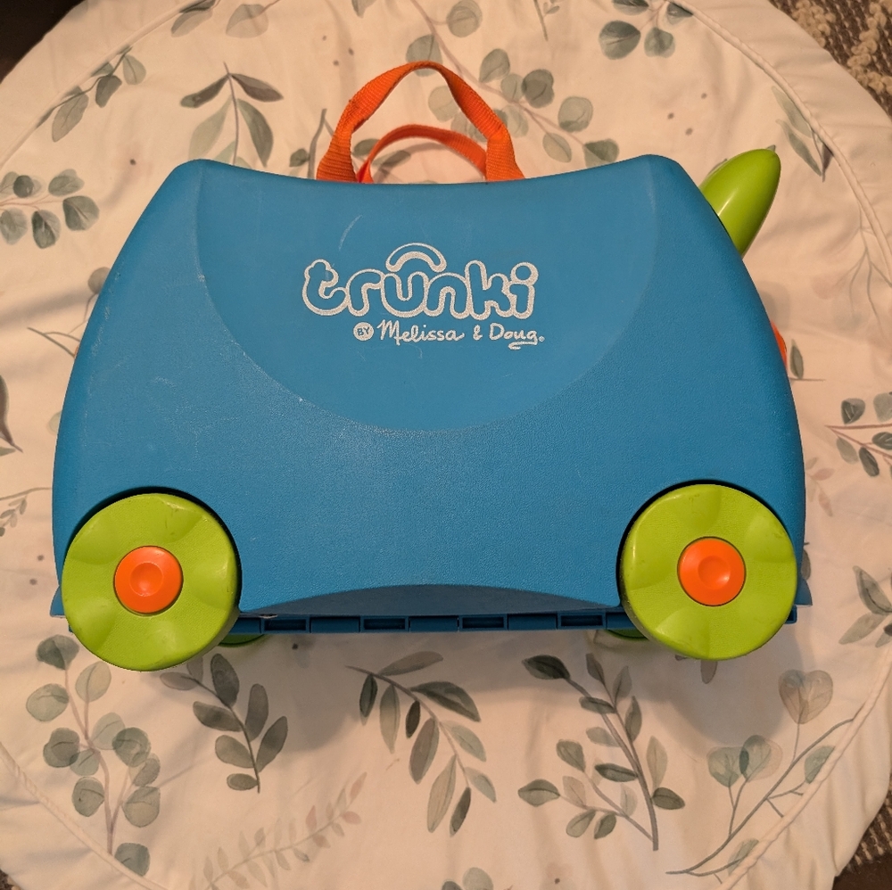 Melissa & Doug blue ride-on Trunki with green wheels and orange handle